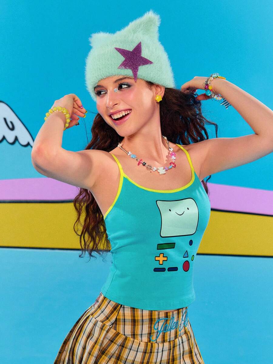 Teal blue slim fit crop camisole top for women featuring a graphic cartoon face print, contrast color trim, and thin spaghetti straps.