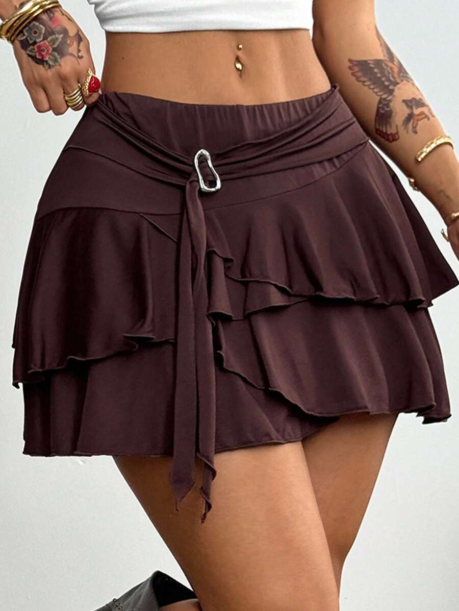 Black low waist tiered mini skirt featuring a ruffle hem and ring accent detail on knitted stretch fabric for women.