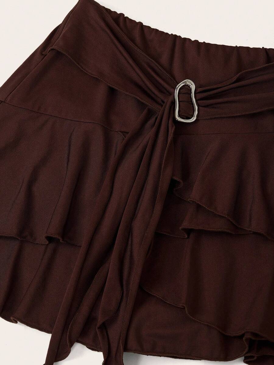Black low waist tiered mini skirt featuring a ruffle hem and ring accent detail on knitted stretch fabric for women.