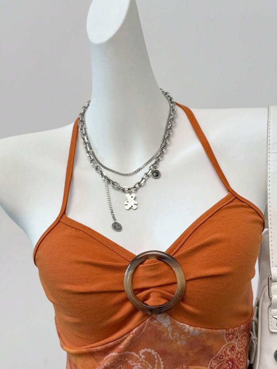 Women's backless halter cami top featuring a paisley print, sleeveless design, and an asymmetrical hem in knitted fabric.