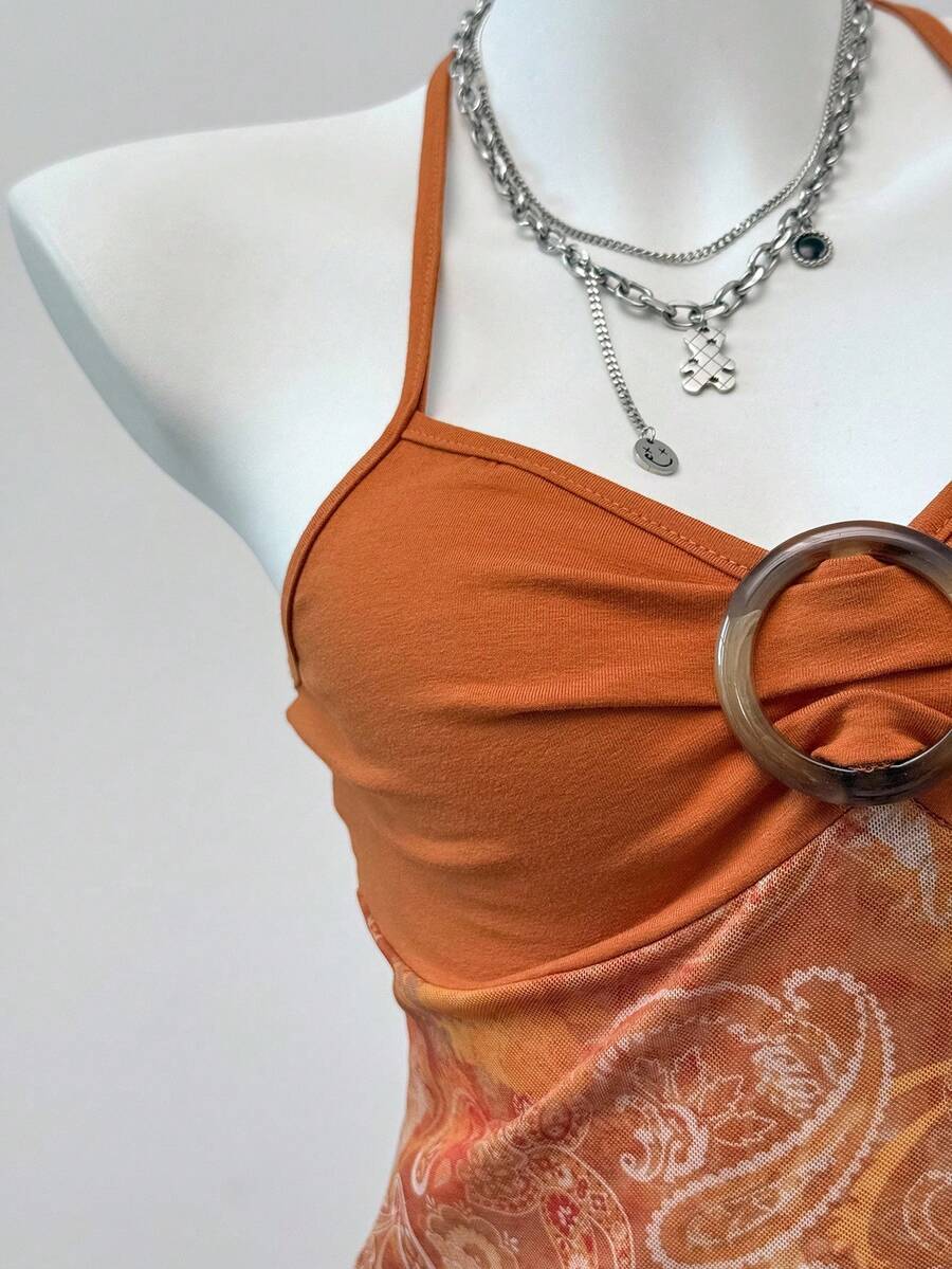 Women's backless halter cami top featuring a paisley print, sleeveless design, and an asymmetrical hem in knitted fabric.