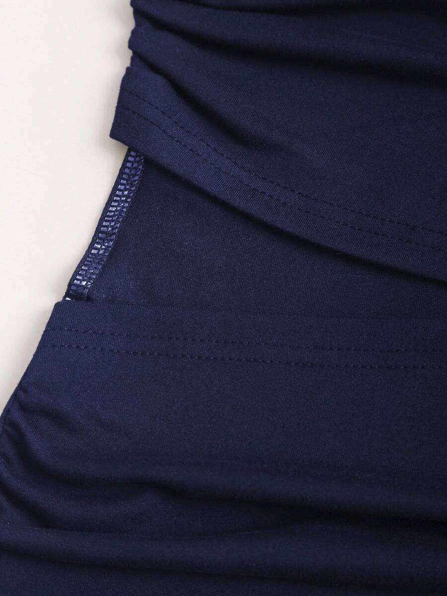 Women's black strapless bodycon mini dress featuring ruched detailing, cut-out design with ring accent, mid-waist pencil hem, and slim fit knitted stretch fabric.