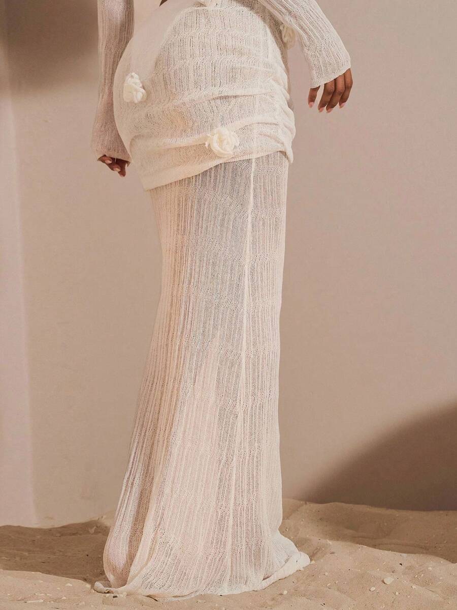 Beige women's knit maxi skirt featuring a pleated 3D floral pattern, low waist, skinny fit, and fishtail hem.