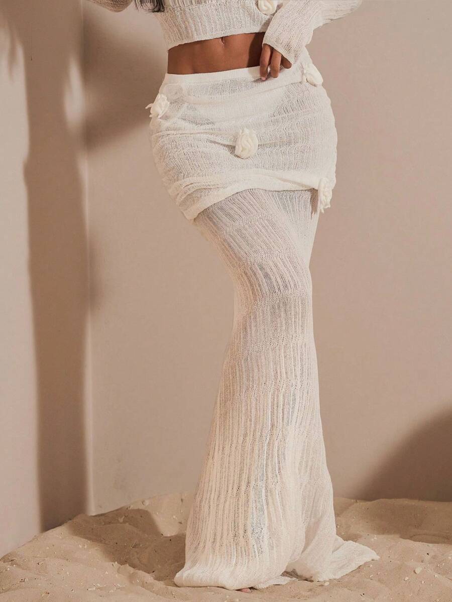 Beige women's knit maxi skirt featuring a pleated 3D floral pattern, low waist, skinny fit, and fishtail hem.