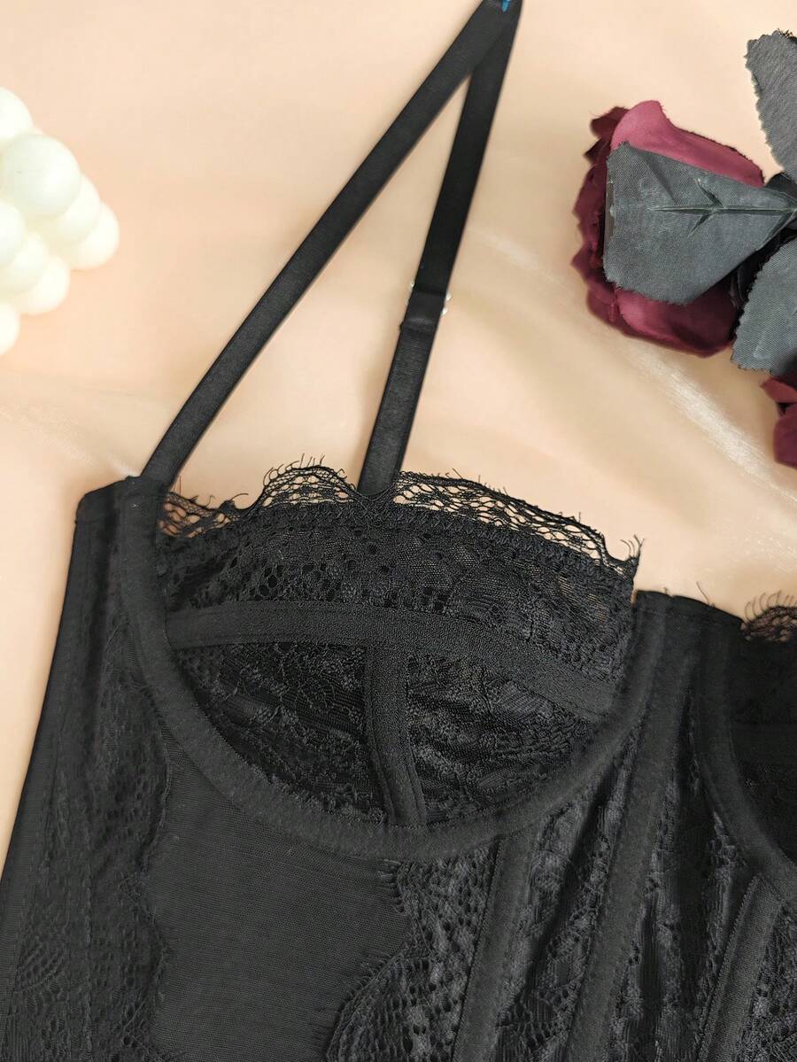 Black seamless lace camisole crop top featuring delicate contrast lace details and thin spaghetti straps.