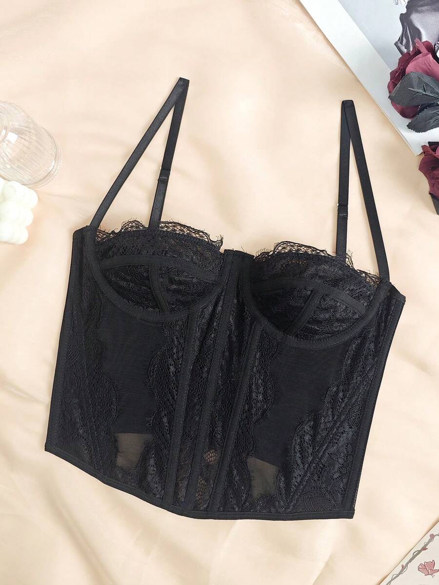 Black seamless lace camisole crop top featuring delicate contrast lace details and thin spaghetti straps.