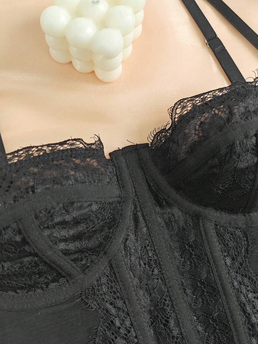 Black seamless lace camisole crop top featuring delicate contrast lace details and thin spaghetti straps.