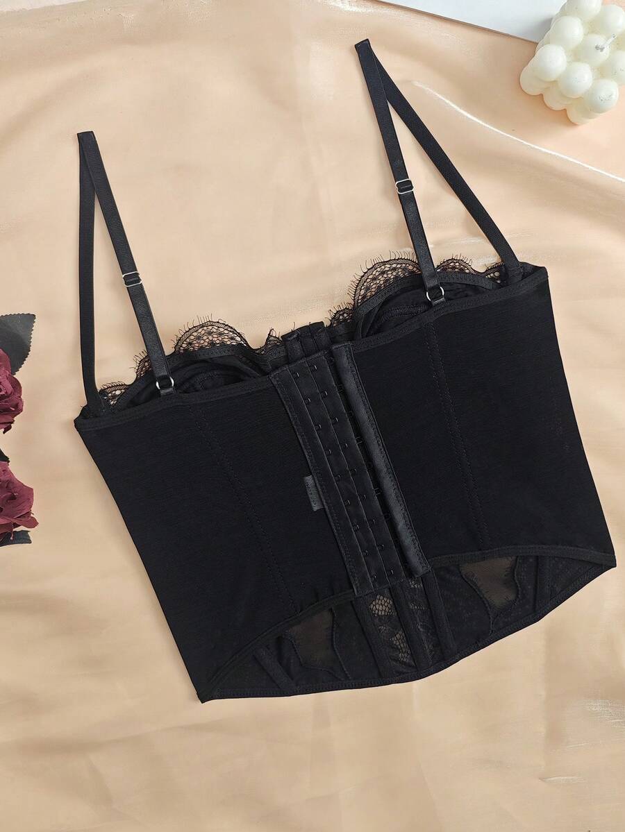 Black seamless lace camisole crop top featuring delicate contrast lace details and thin spaghetti straps.