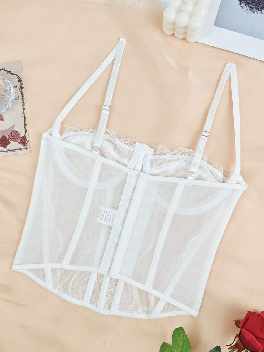 Front view of a black seamless lace camisole crop top featuring delicate spaghetti straps and intricate contrast lace detailing.