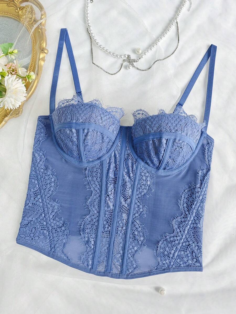 Front view of a black seamless lace camisole crop top featuring delicate spaghetti straps and intricate contrast lace detailing.