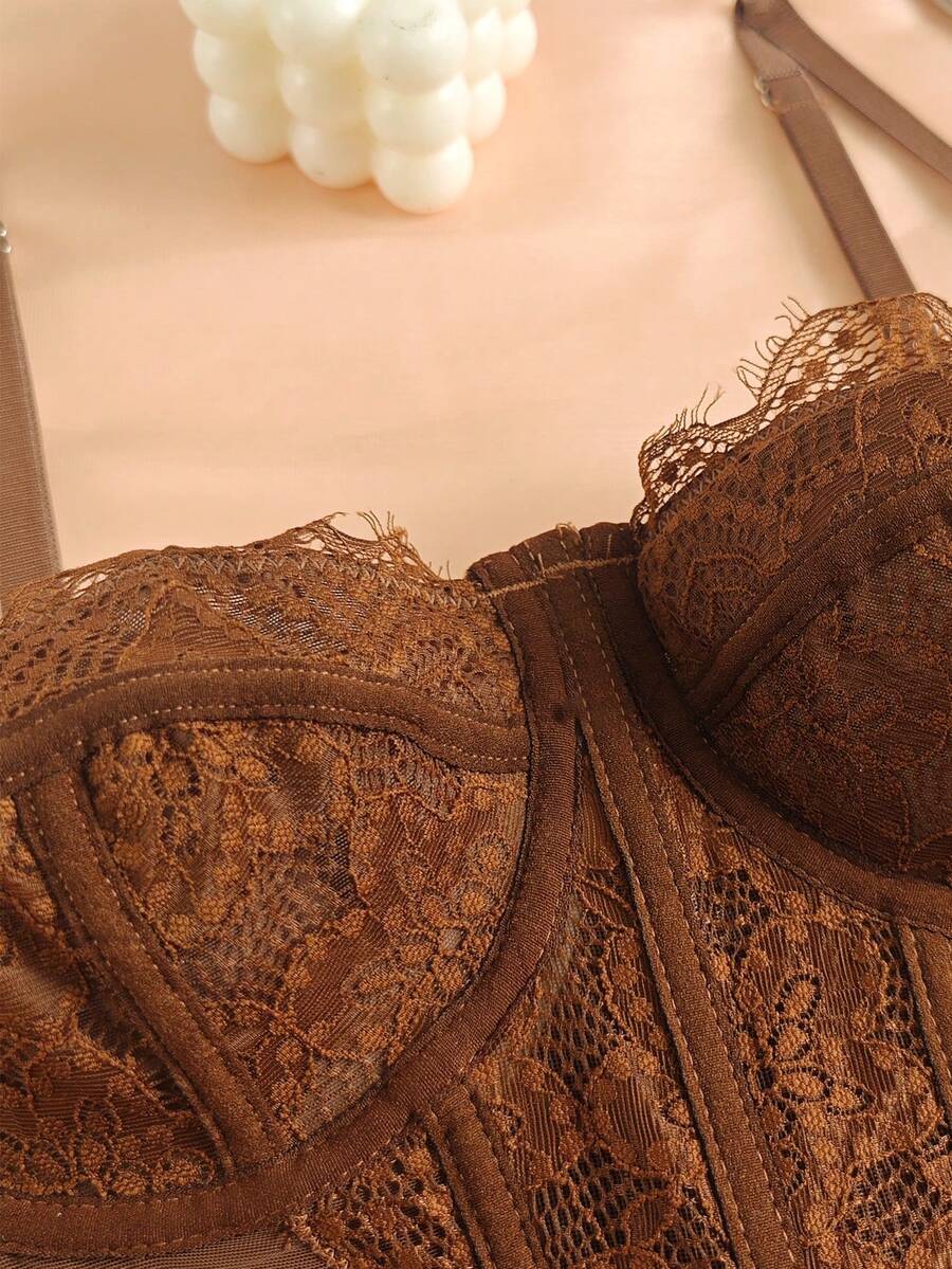 Front view of a black seamless lace camisole crop top featuring delicate spaghetti straps and intricate contrast lace detailing.
