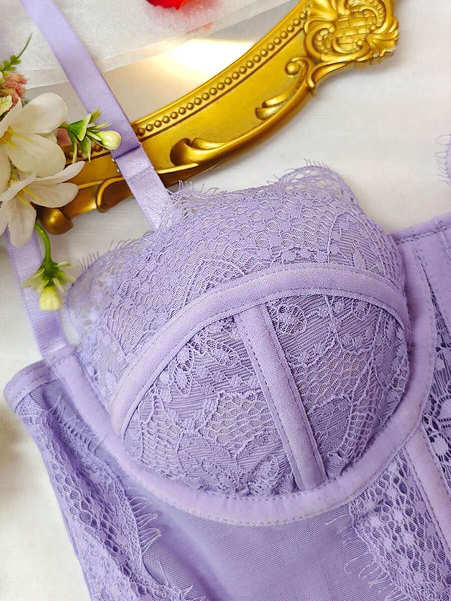 Front view of a black seamless lace camisole crop top featuring delicate spaghetti straps and intricate contrast lace detailing.