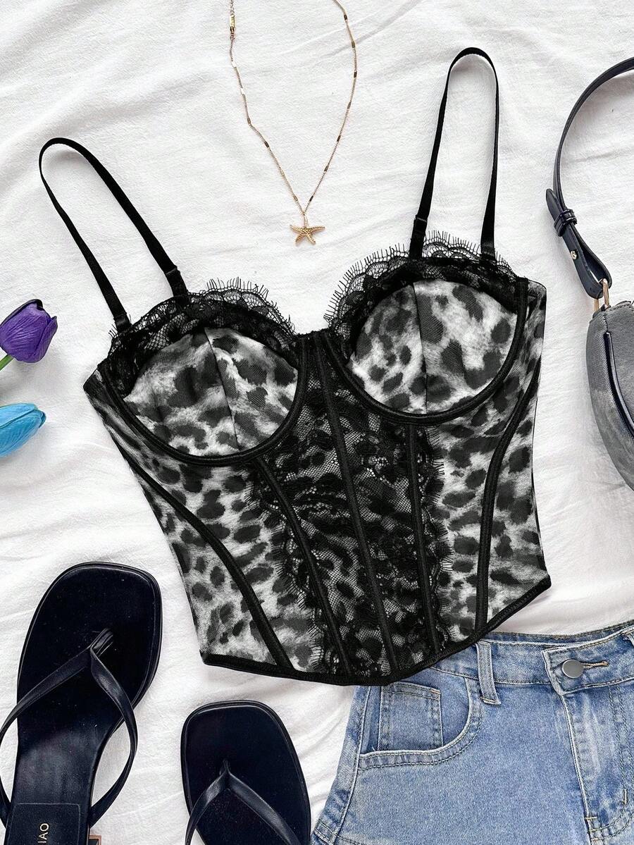 Women's lace bustier camisole top with spaghetti straps, contrast lace, lace-up detail, and an asymmetrical hem in a slim fit design.