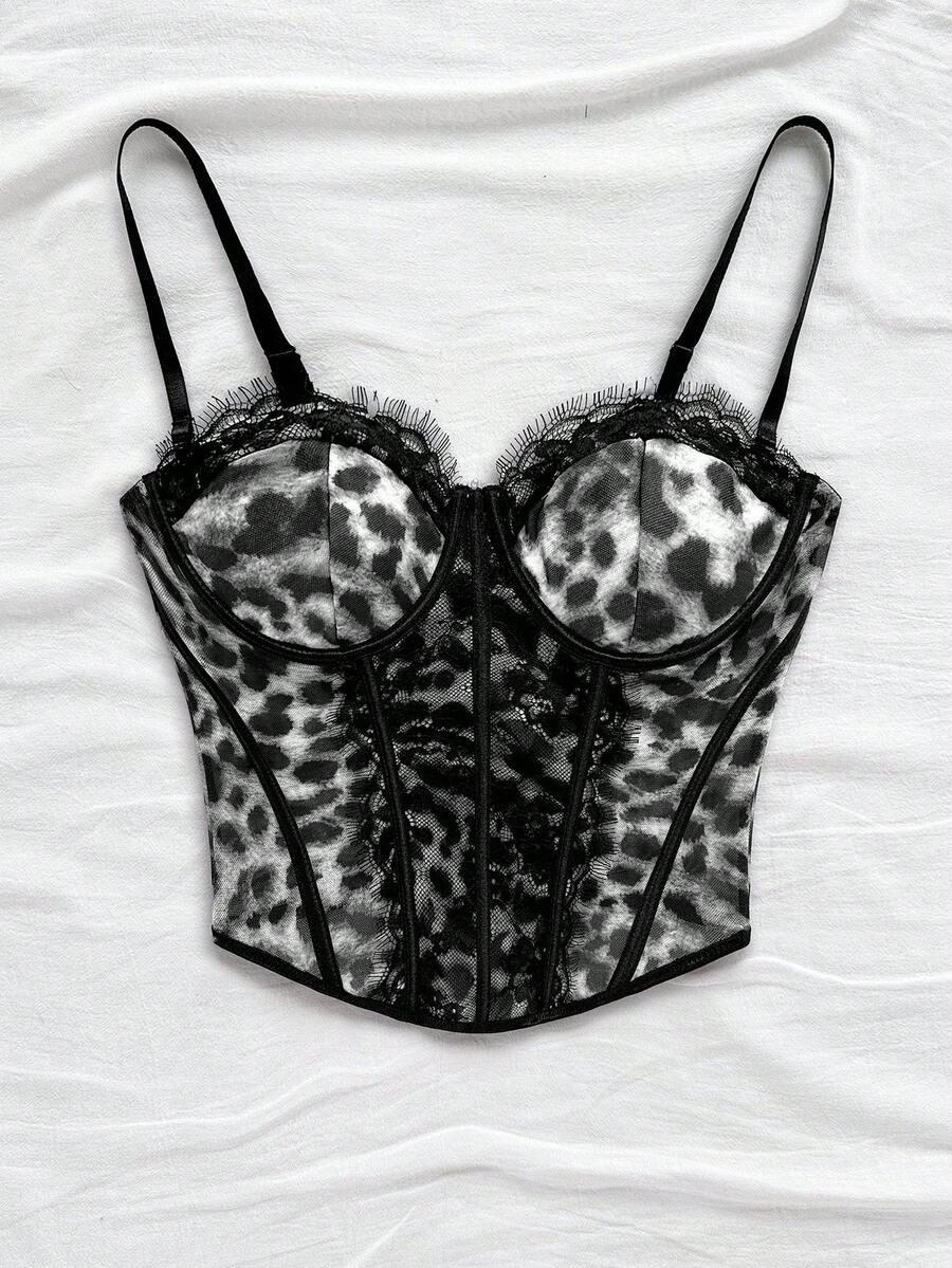Women's lace bustier camisole top with spaghetti straps, contrast lace, lace-up detail, and an asymmetrical hem in a slim fit design.