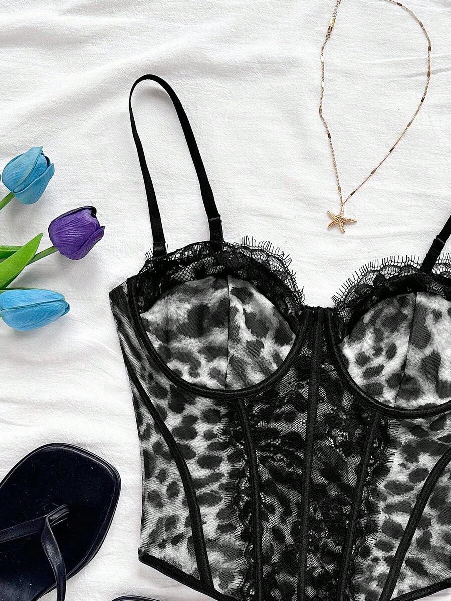 Women's lace bustier camisole top with spaghetti straps, contrast lace, lace-up detail, and an asymmetrical hem in a slim fit design.