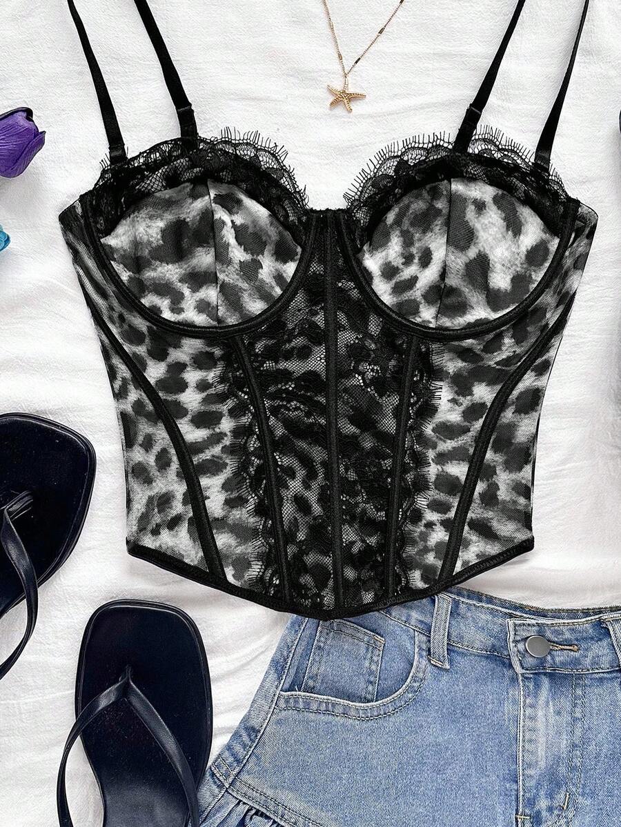 Women's lace bustier camisole top with spaghetti straps, contrast lace, lace-up detail, and an asymmetrical hem in a slim fit design.