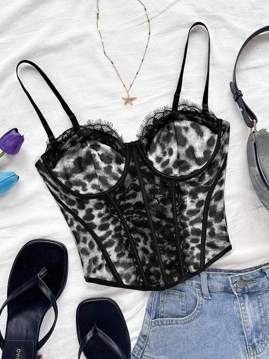 Women's lace bustier camisole top with spaghetti straps, contrast lace, lace-up detail, and an asymmetrical hem in a slim fit design.