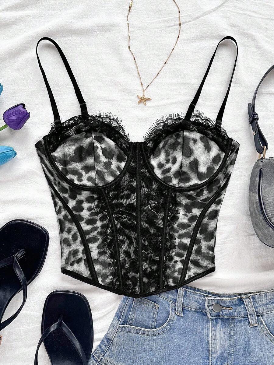 Women's lace bustier camisole top with spaghetti straps, contrast lace, lace-up detail, and an asymmetrical hem in a slim fit design.
