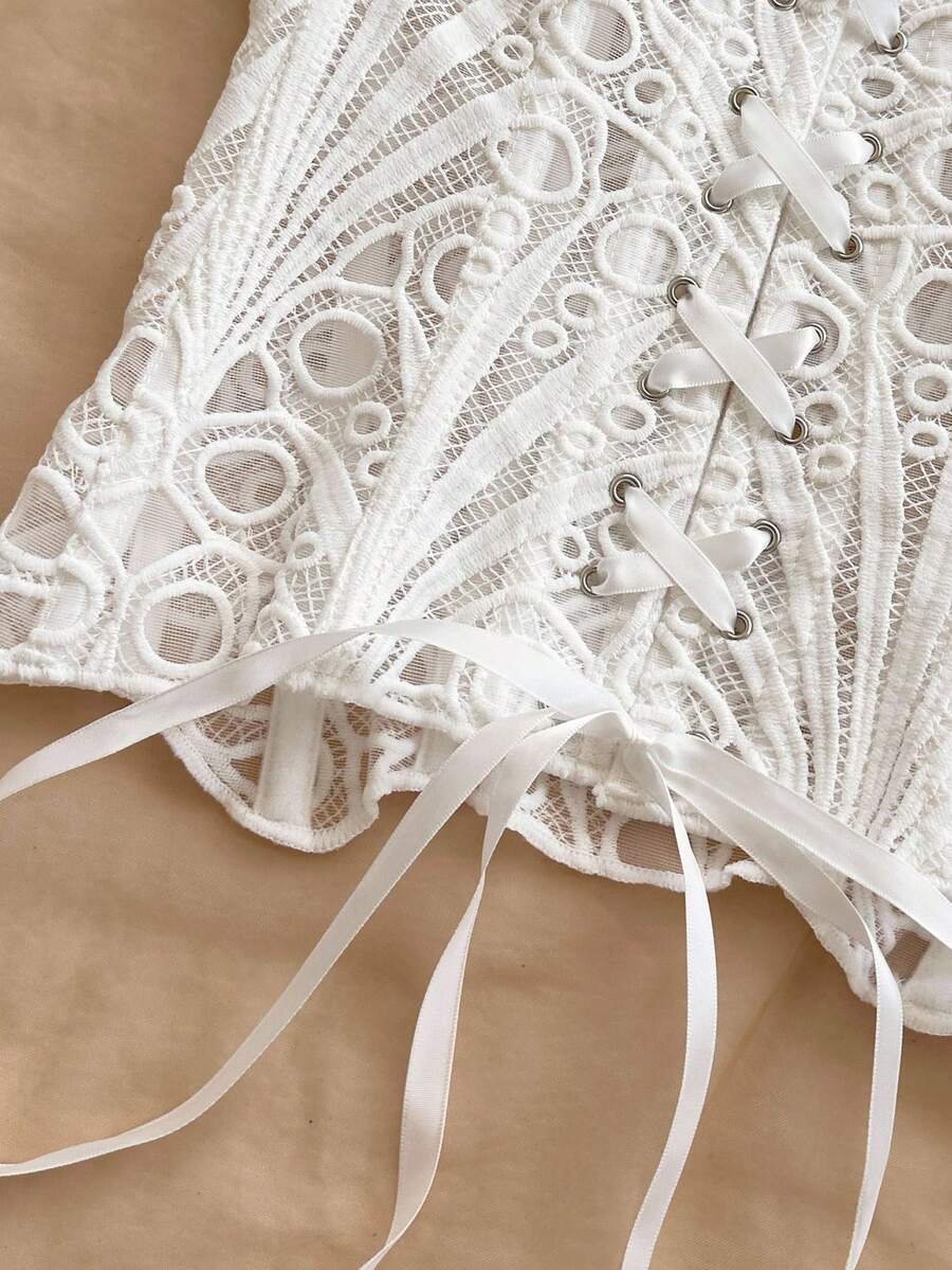 Women’s strapless corset bustier top with lace-up detail, asymmetrical embroidery, semi-sheer finish, and slim fit.