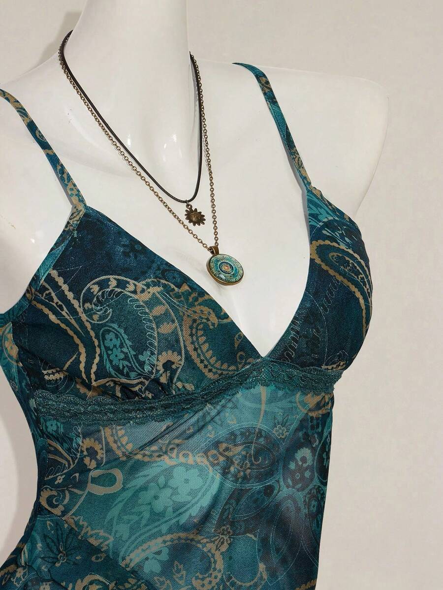 Women's burgundy floral graphic print mesh camisole top featuring an asymmetrical hem, backless cut, and spaghetti straps.