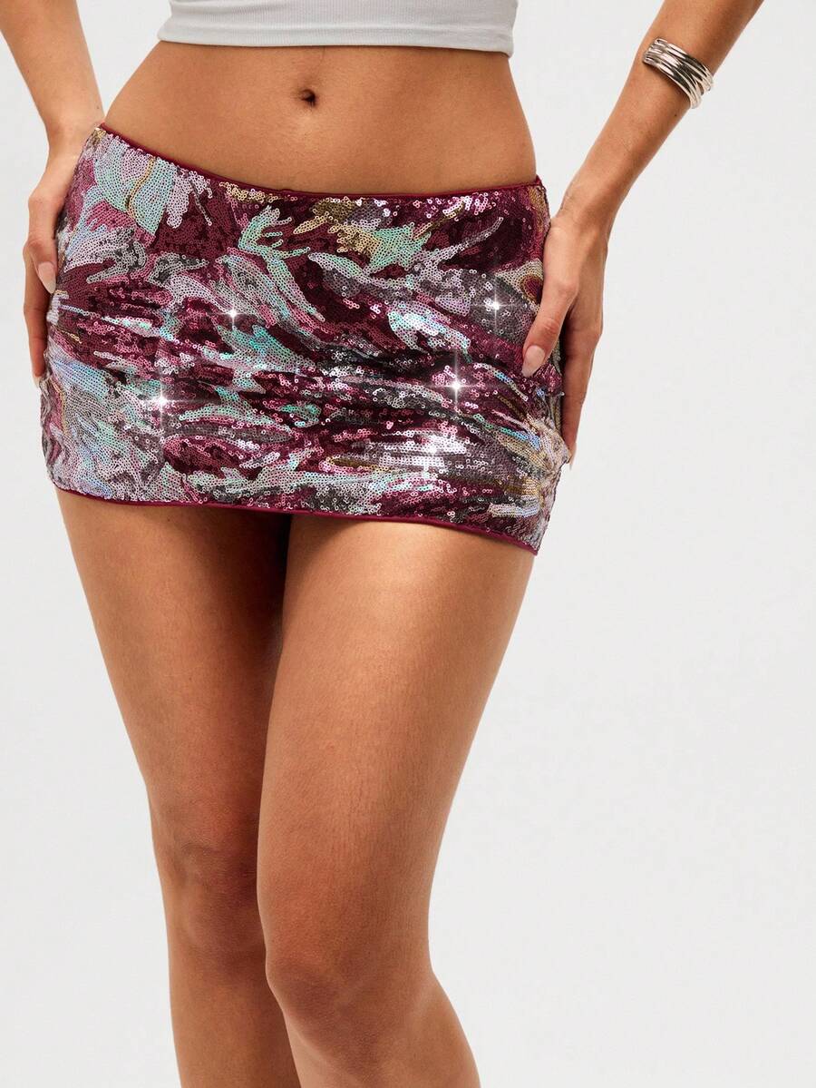 Burgundy shiny sequin bodycon mini skirt for women with low waist design, floral plant embroidery, and zipper detail.