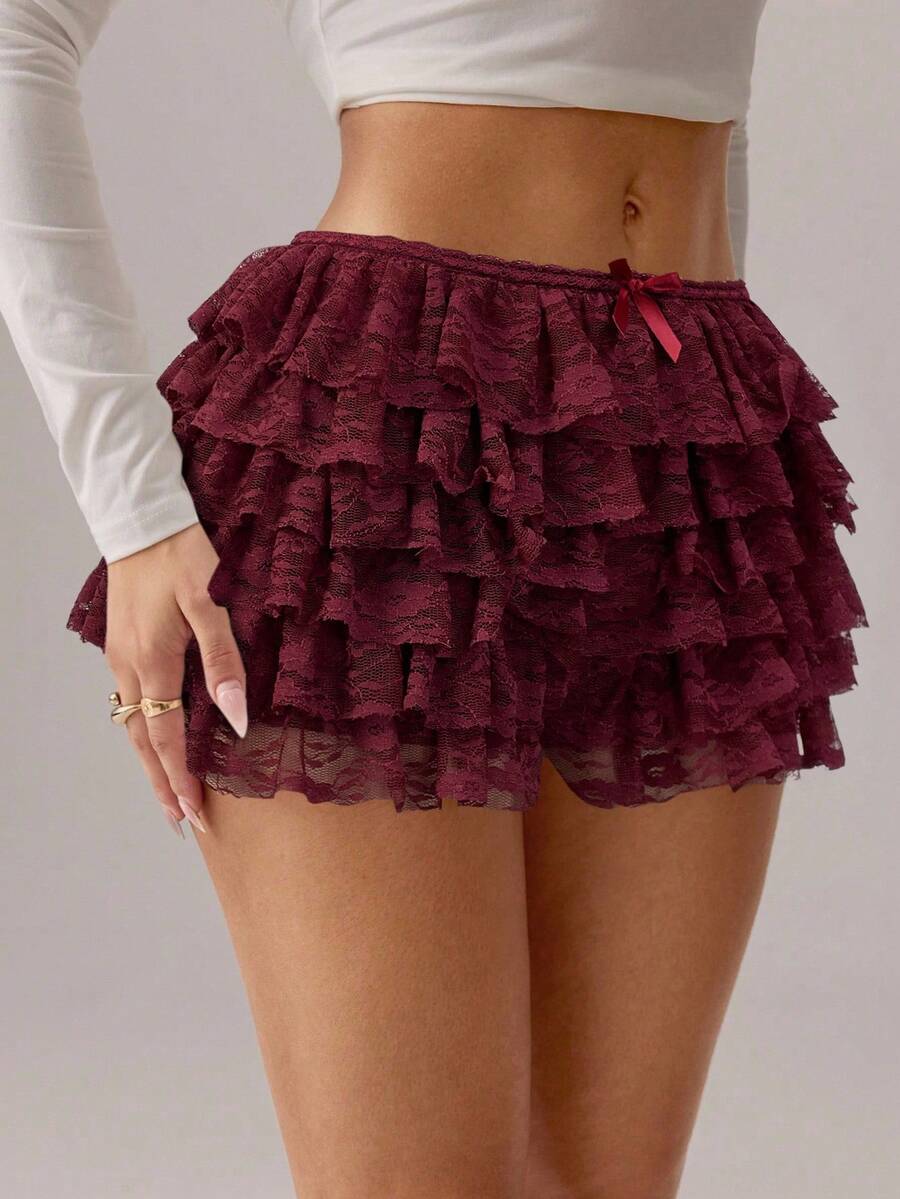 Apricot tiered lace ruffle hem low waist shorts for women featuring elastic waist and lined semi-sheer knit fabric.