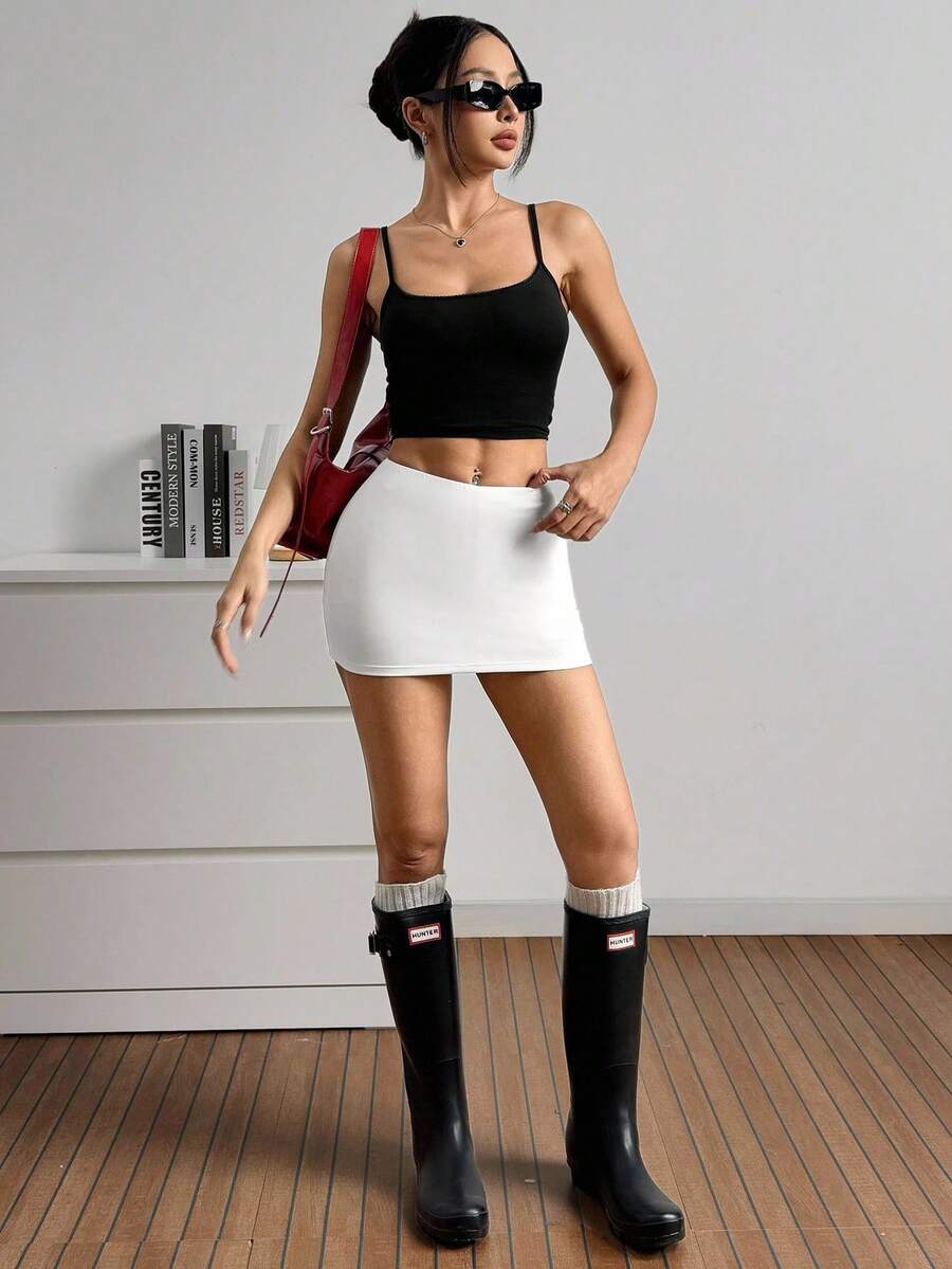 Women's black casual low rise bodycon mini skort with built-in shorts in knitted plain stretch fabric.