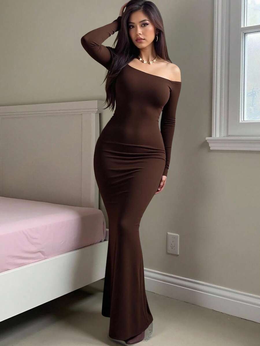 Woman wearing an elegant off-the-shoulder bodycon long dress with backless design and pencil silhouette in high-stretch knitted fabric.