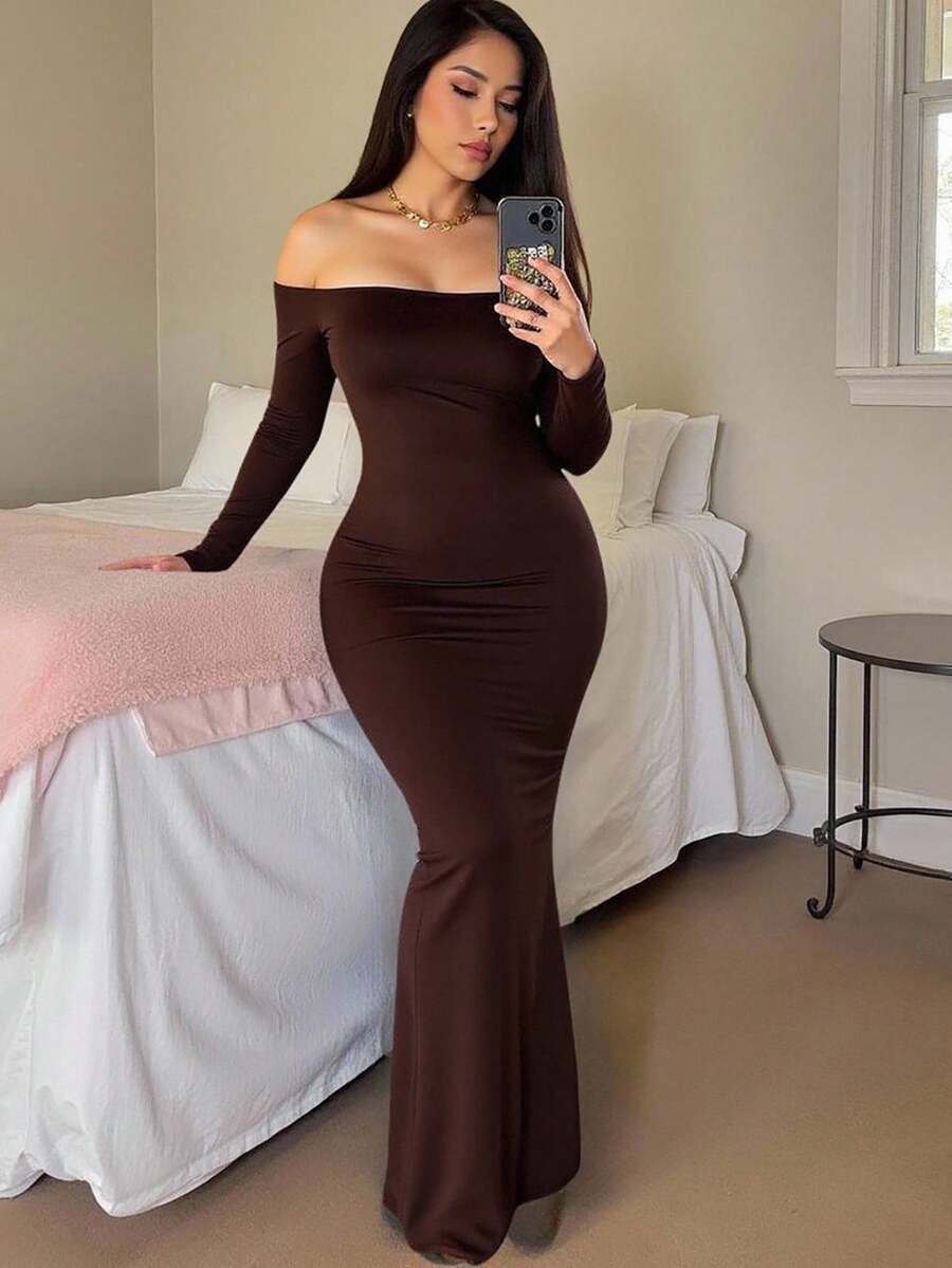 Woman wearing an elegant off-the-shoulder bodycon long dress with backless design and pencil silhouette in high-stretch knitted fabric.