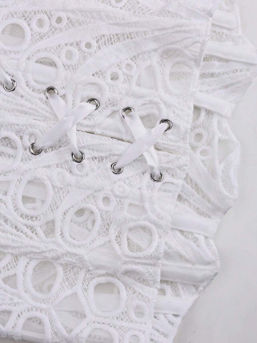 Women's white strapless lace corset crop top featuring boned structure, cut-out details, lace-up back, and asymmetrical hem.