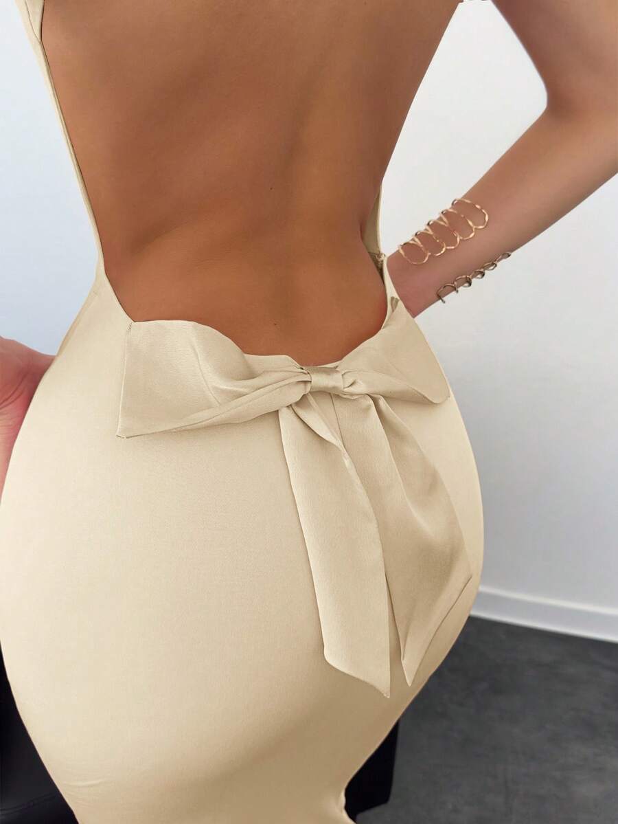 Beige sleeveless backless cami maxi dress for women featuring bow decor, split hem, and slim fit knitted fabric.