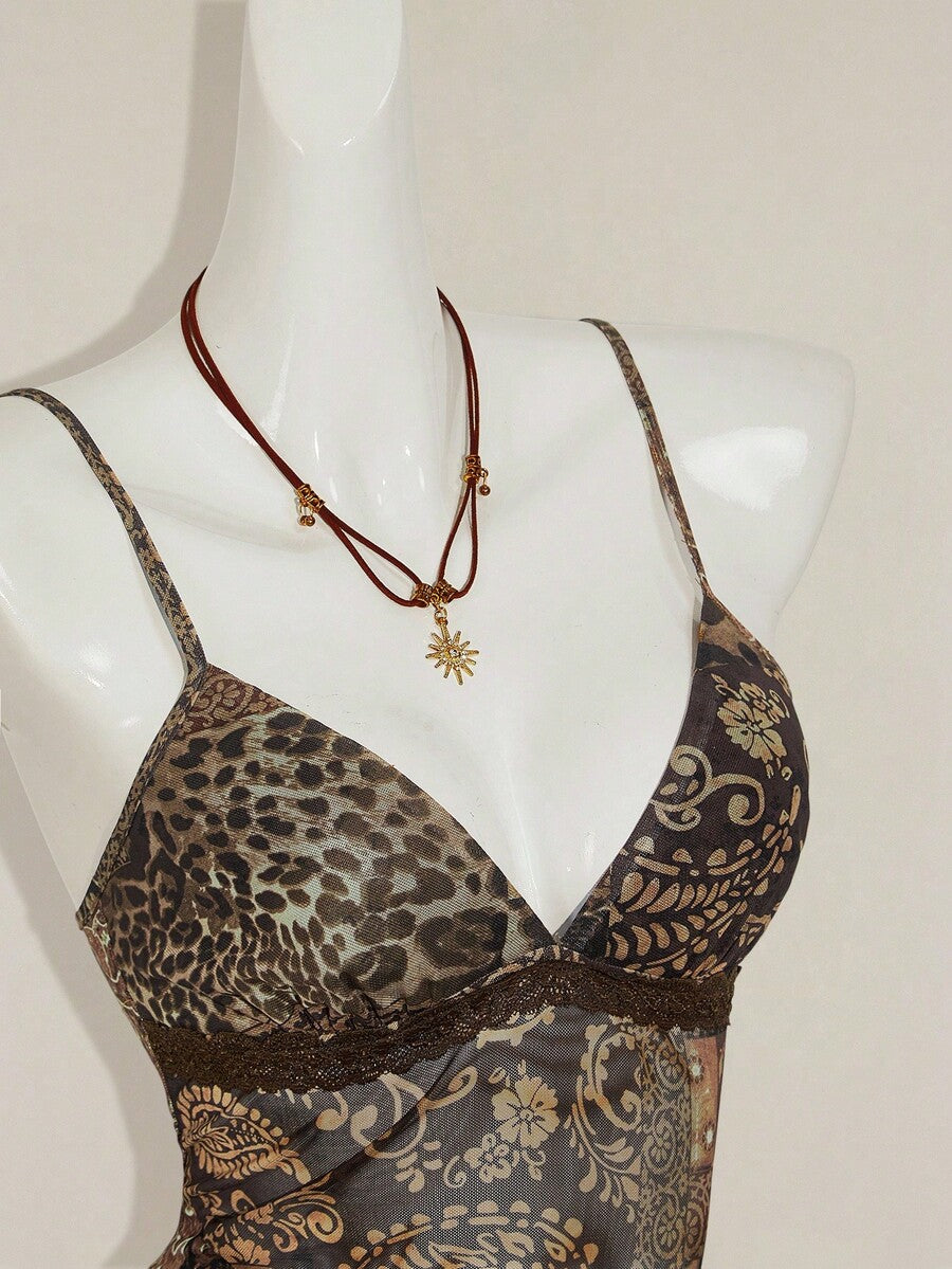 Women's burgundy floral graphic print mesh camisole top featuring an asymmetrical hem, backless cut, and spaghetti straps.