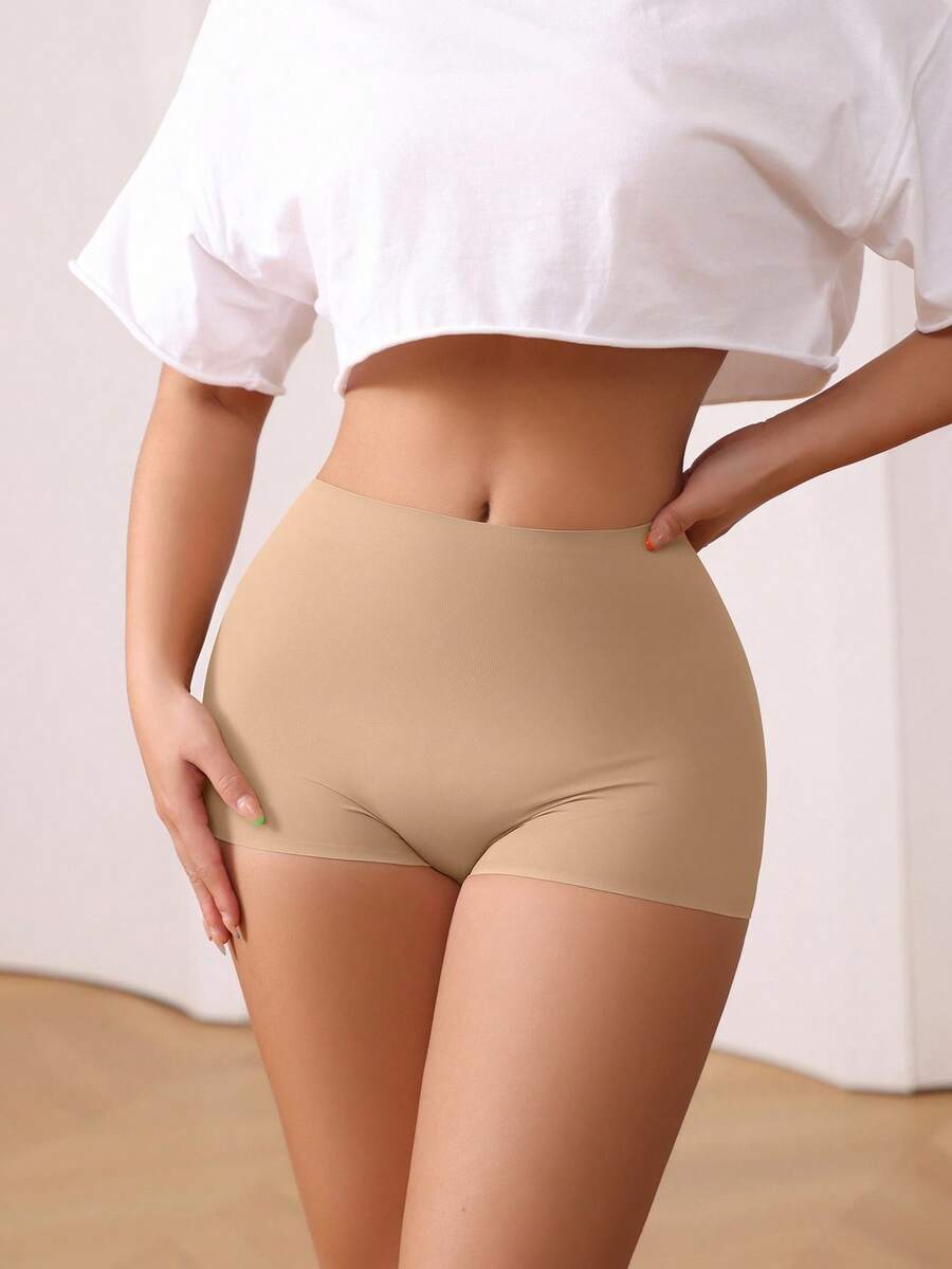 Women's black high stretch shapewear shorts with a mid waist fit and semi-sheer fabric.