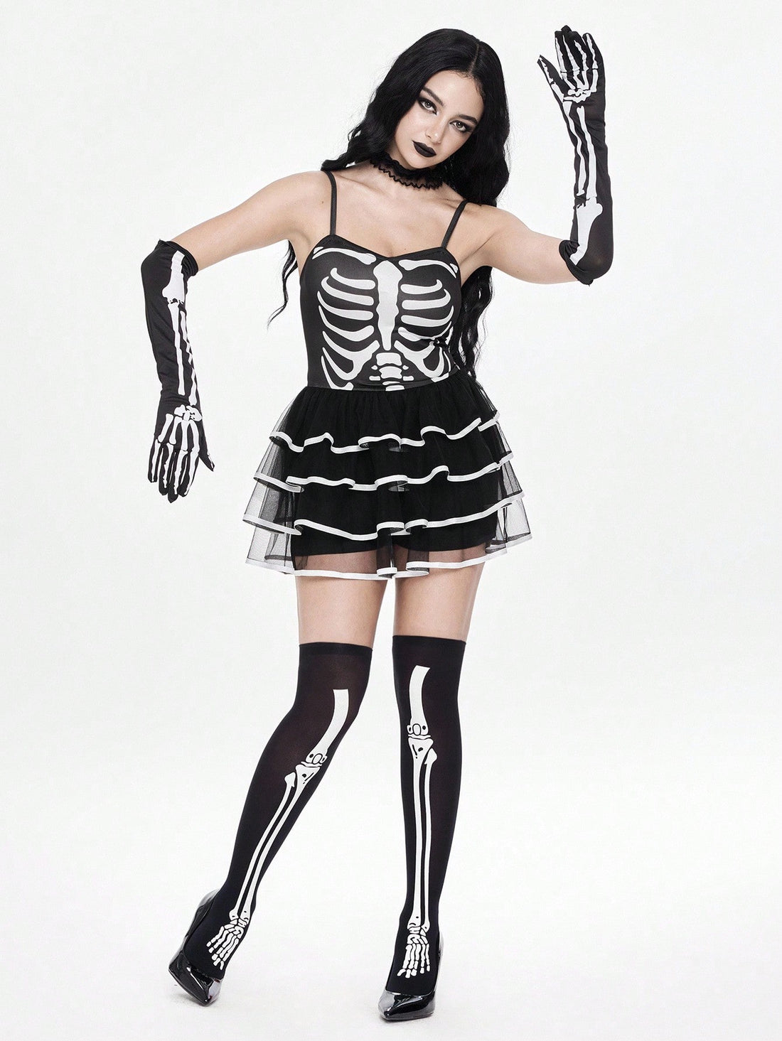 Women wearing a black goth skeleton mesh suspender mini cake dress featuring tiered ruffle hem, spaghetti straps, high waist slim fit, and matching arm sleeves.