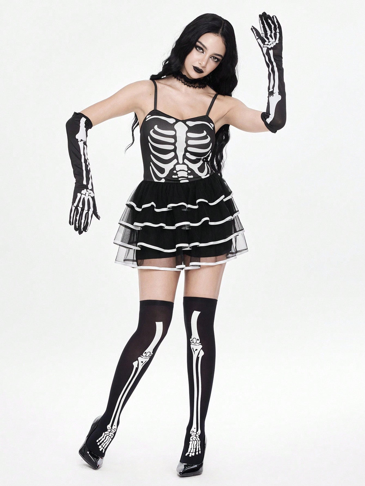 Women wearing a black goth skeleton mesh suspender mini cake dress featuring tiered ruffle hem, spaghetti straps, high waist slim fit, and matching arm sleeves.
