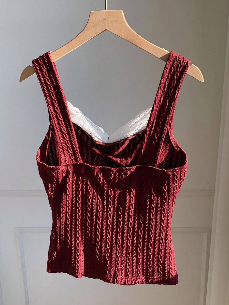 Black and white polka dot knit camisole tank top featuring delicate contrast lace trim, a cute bow accent at the sweetheart neckline, and slender shoulder straps.