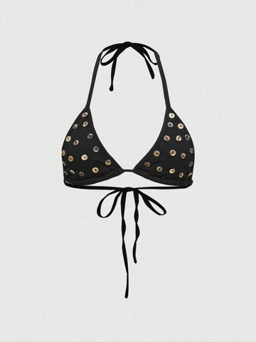 Black halter micro crop top featuring a backless tie-back design with shell button details on a woman.