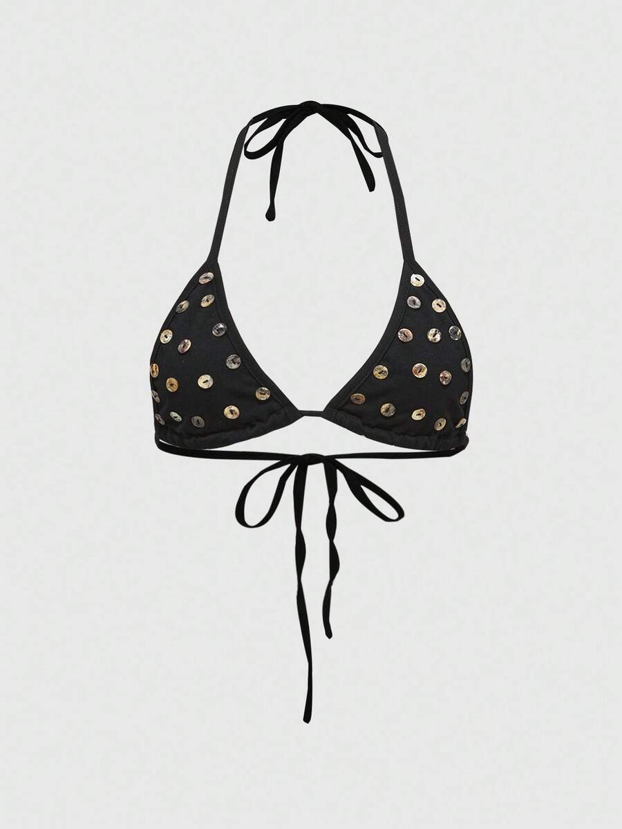 Black halter micro crop top featuring a backless tie-back design with shell button details on a woman.