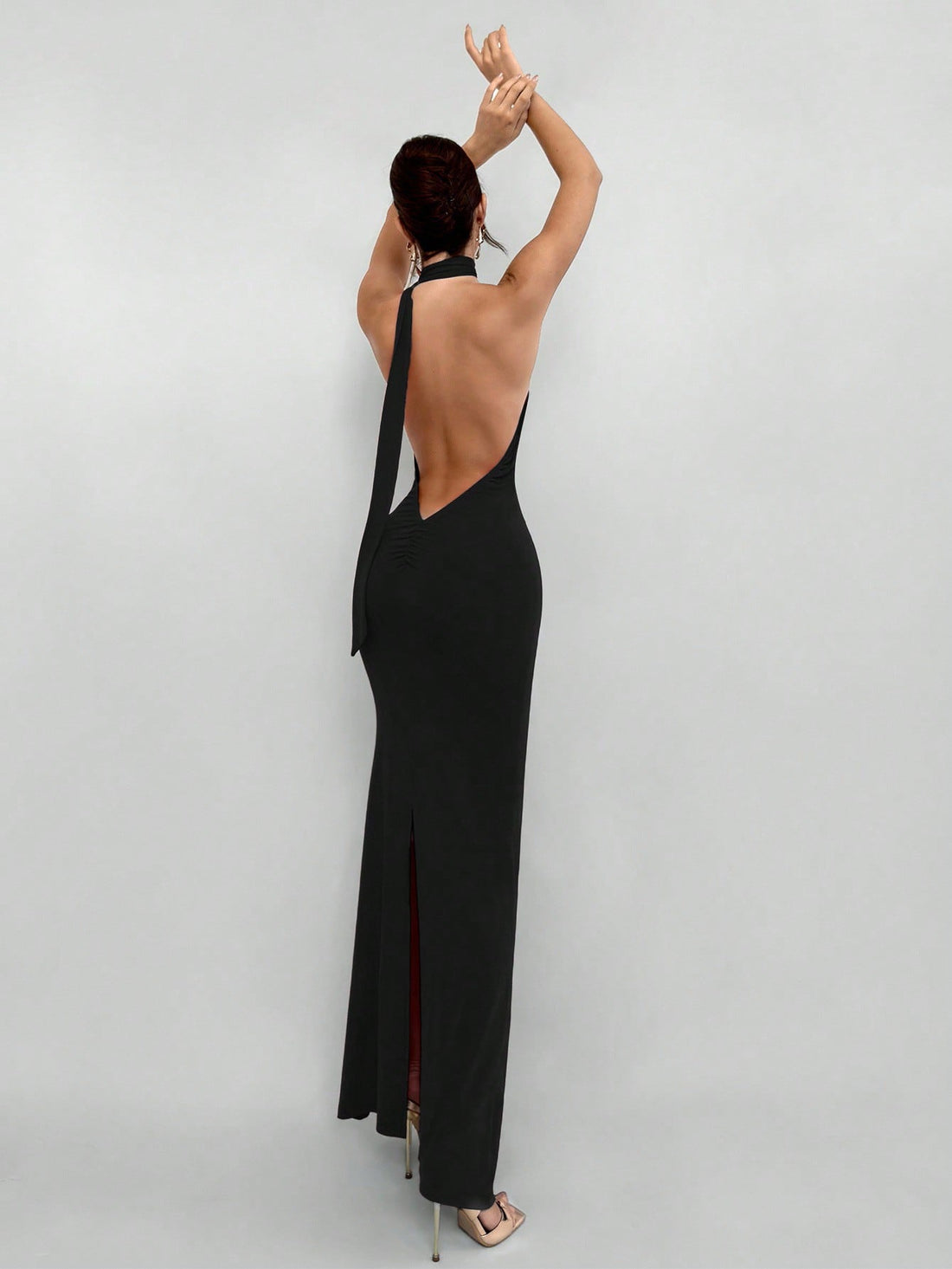 Women's backless halter maxi dress featuring a split thigh, knot detail, slim fit silhouette, and elegant mid-waist cut.