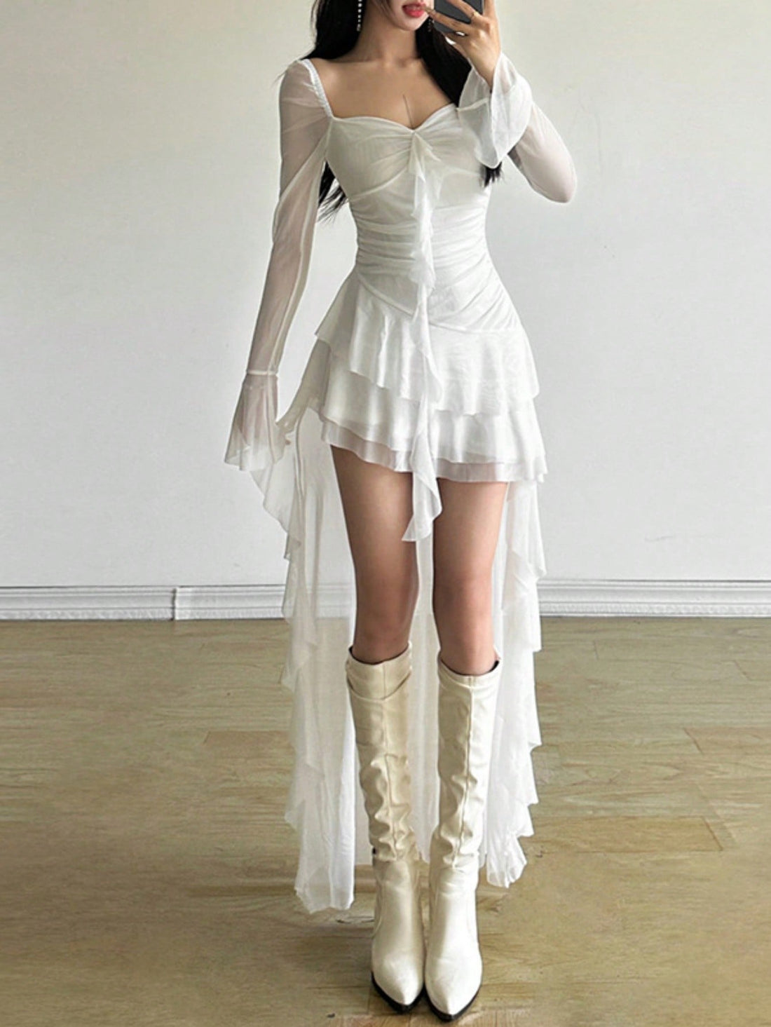 Woman wearing a solid off-the-shoulder asymmetrical midi dress with long flare sleeves.