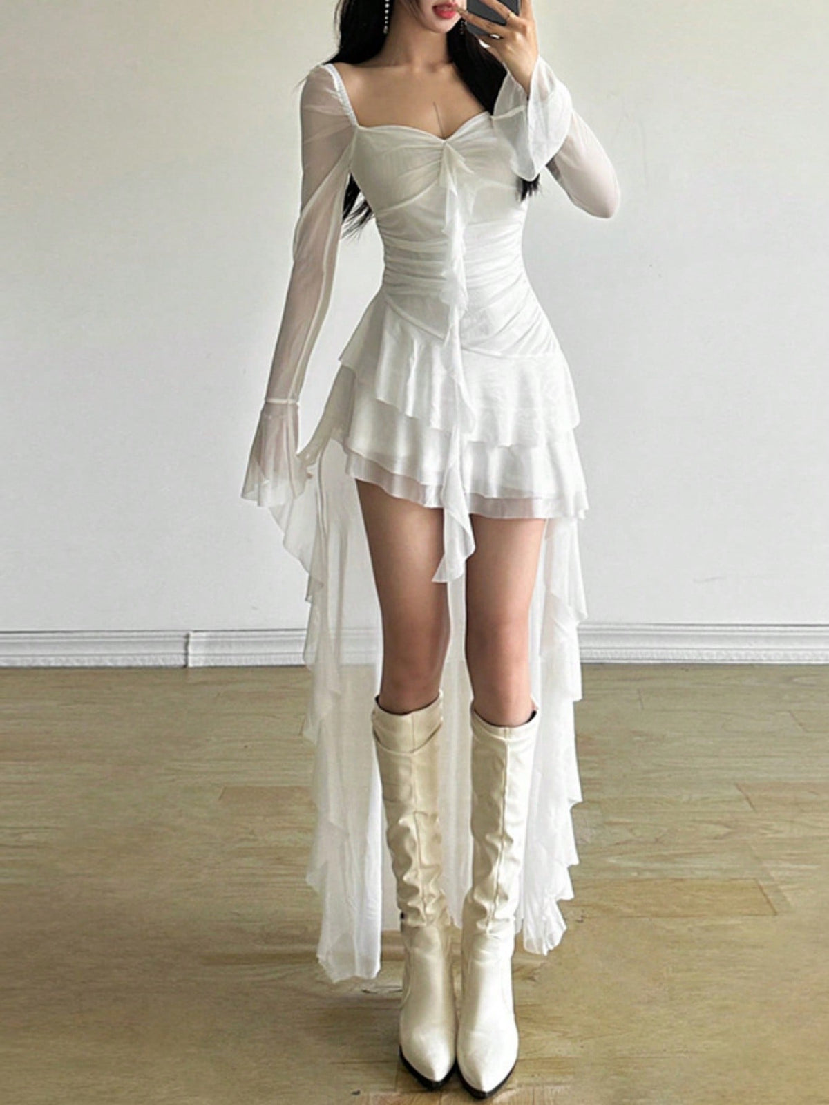 Woman wearing a solid off-the-shoulder asymmetrical midi dress with long flare sleeves.
