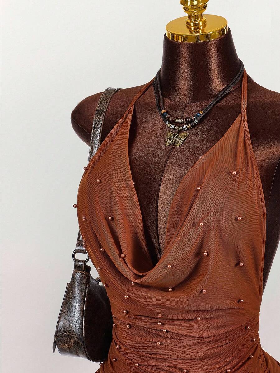 Women's black halter mini dress featuring a backless draped design, semi-sheer mesh fabric, and slim pencil fit.