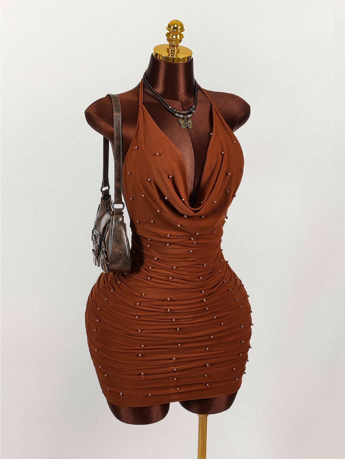 Women's black halter mini dress featuring a backless draped design, semi-sheer mesh fabric, and slim pencil fit.