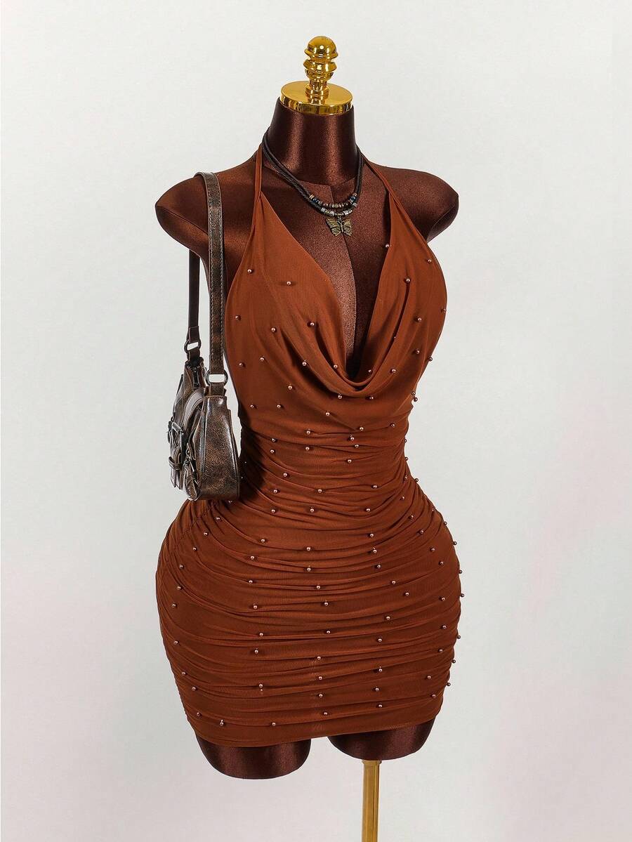 Women's black halter mini dress featuring a backless draped design, semi-sheer mesh fabric, and slim pencil fit.
