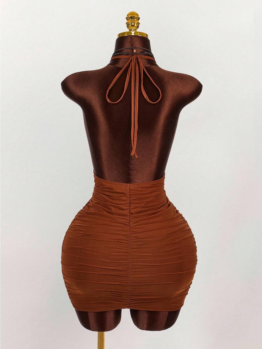 Women's black halter mini dress featuring a backless draped design, semi-sheer mesh fabric, and slim pencil fit.