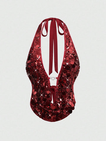 A woman wearing a burgundy sequin halter camisole top featuring a backless asymmetrical design.