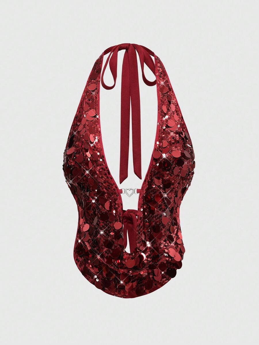 A woman wearing a burgundy sequin halter camisole top featuring a backless asymmetrical design.