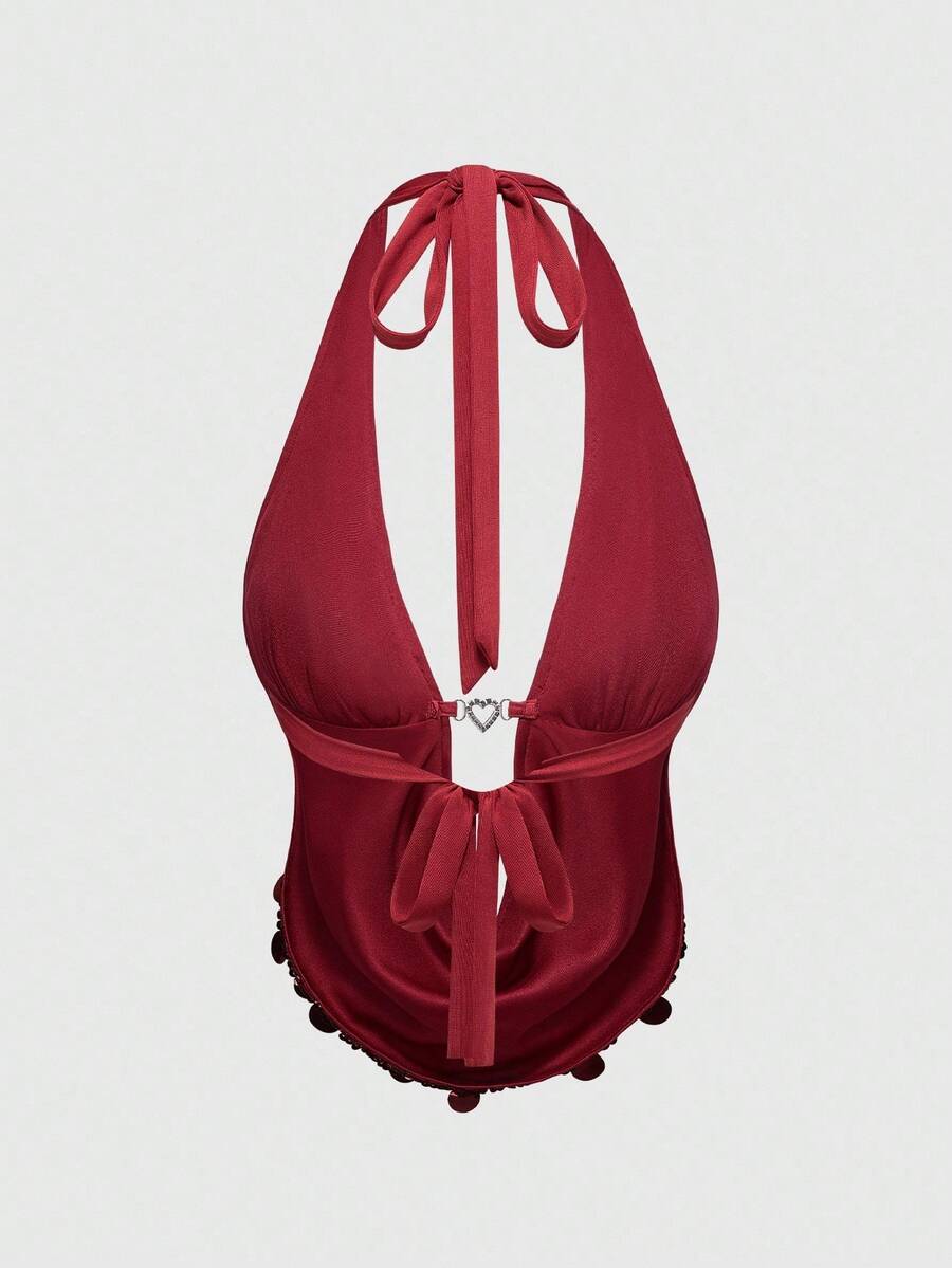 A woman wearing a burgundy sequin halter camisole top featuring a backless asymmetrical design.