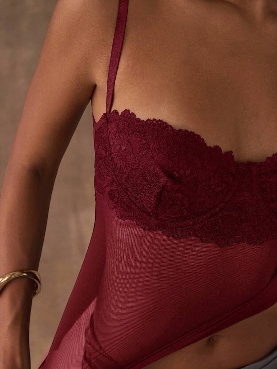 Women's black contrast lace camisole with spaghetti straps, cup detail, semi-sheer finish, and slim fit for going out or date night.