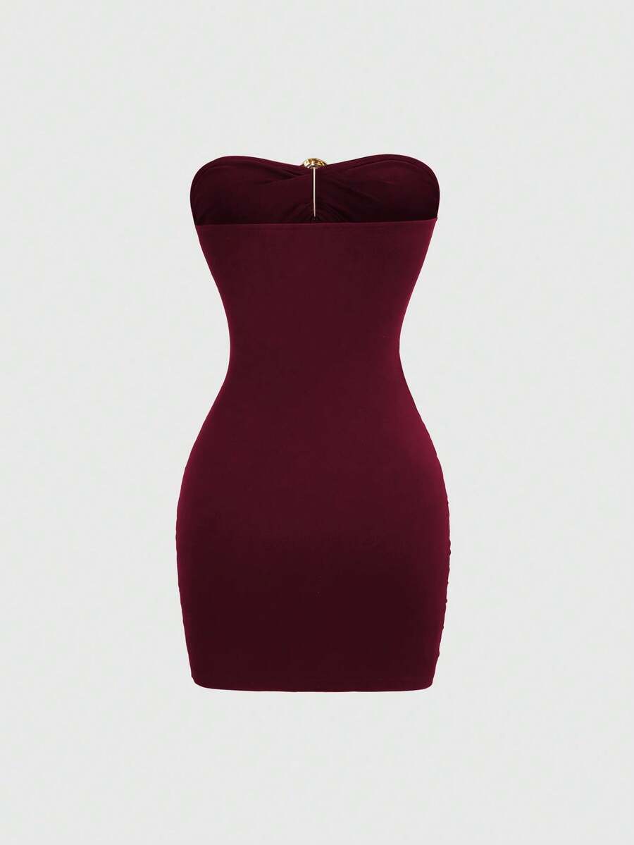 Women's black strapless bodycon mini dress featuring ruched detailing, cut-out design with ring accent, mid-waist pencil hem, and slim fit knitted stretch fabric.